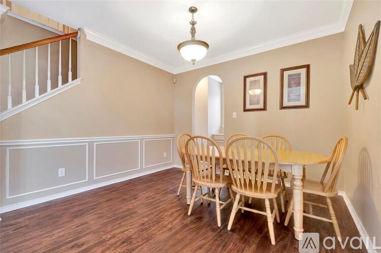 A dining room with a wooden table and chairs.
