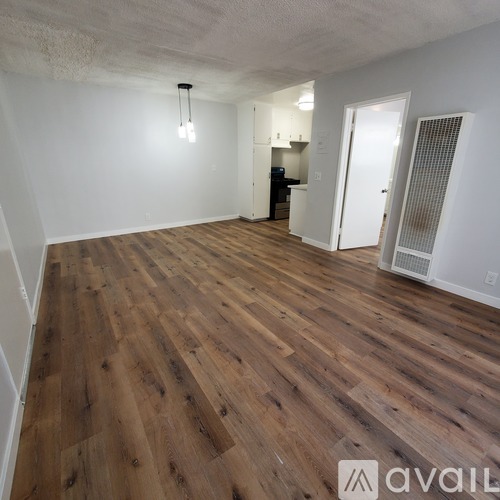 A room with wooden flooring and white walls.