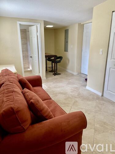 A living room with a red couch and a black chair.