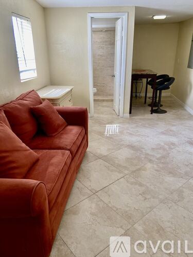 A living room with a red couch and a white table.