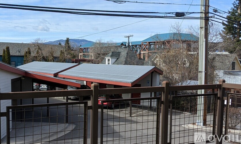 A view of a residential area with houses and a bridge in the background.