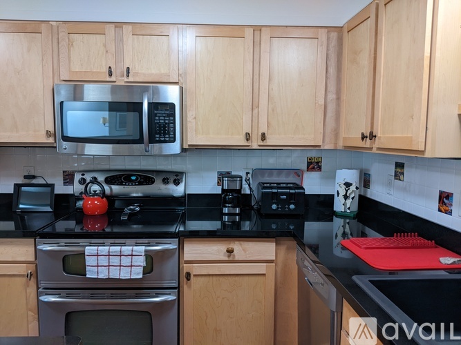 A kitchen with wooden cabinets and a black countertop.