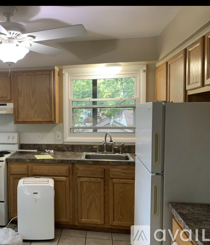 A kitchen with wooden cabinets and a white refrigerator.