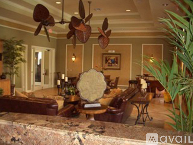 A living room with a couch, chairs, and a fan.