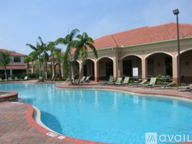 A pool with a red border and a building in the background.