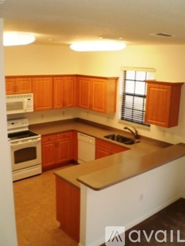 A kitchen with wooden cabinets and white appliances.