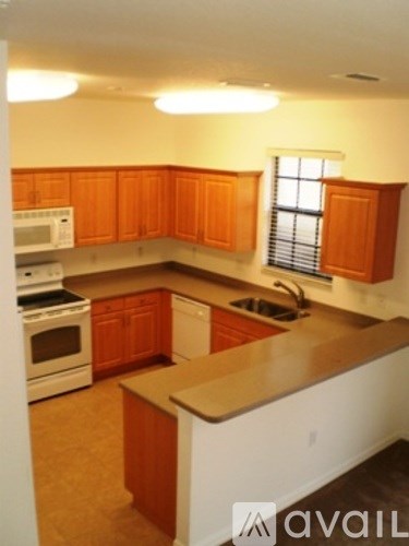 A kitchen with wooden cabinets and white appliances.