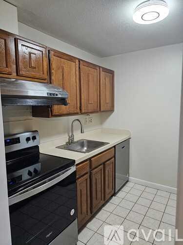 A kitchen with wooden cabinets and a stove top oven.