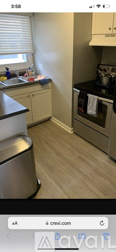 A kitchen with a stove top oven and a trash can.