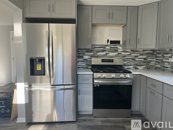 A modern kitchen with a stainless steel refrigerator and oven.