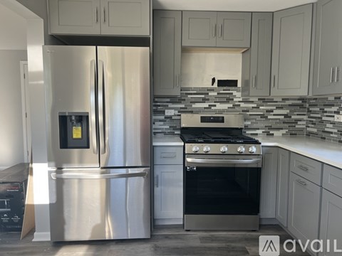 A modern kitchen with a stainless steel refrigerator and oven.
