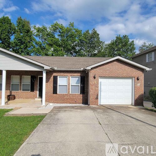 A house with a white garage door and a brown brick exterior.
