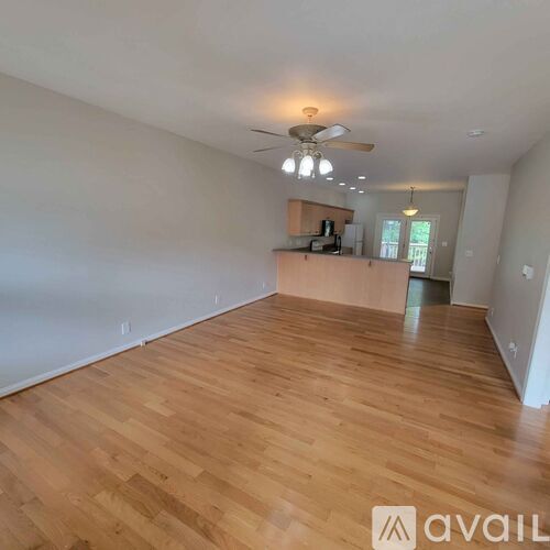A room with wooden flooring and a ceiling fan.