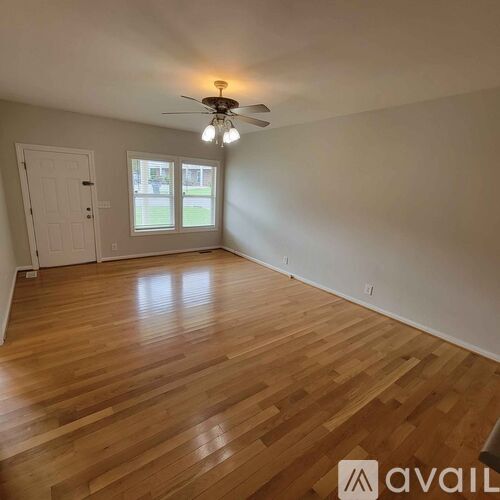 A room with wooden flooring and a ceiling fan.