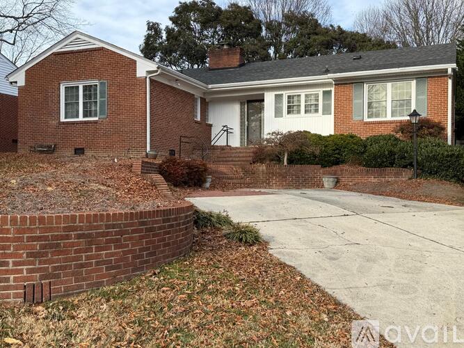 A brick house with a white door and windows.