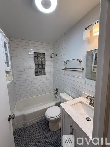 A bathroom with a white toilet, a white sink, and a white bathtub.