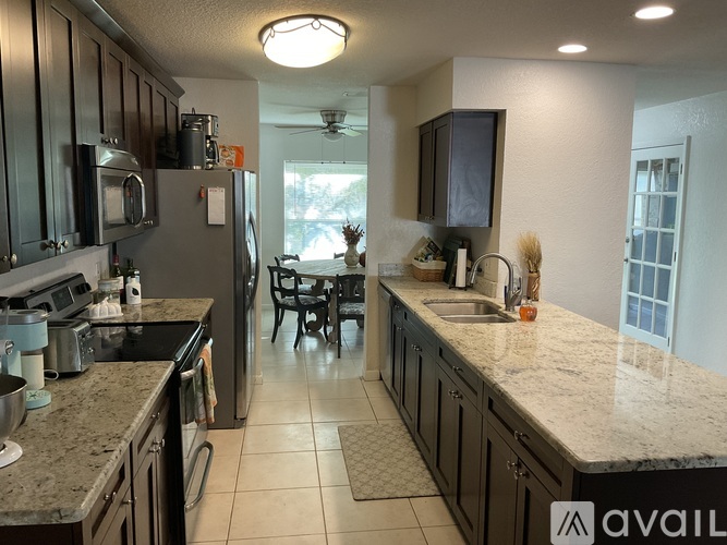 A kitchen with granite countertops and black cabinets.