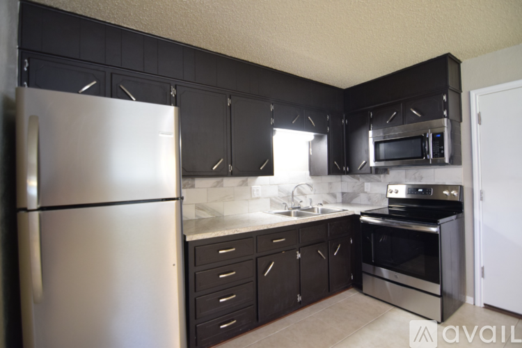 A kitchen with black cabinets and stainless steel appliances.