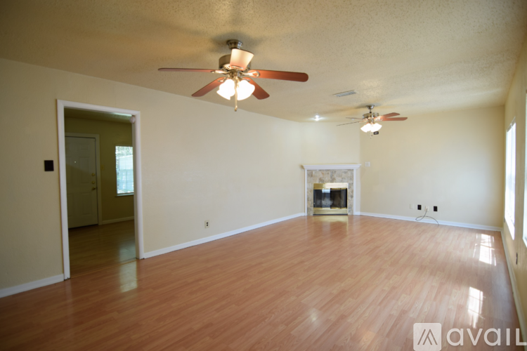 A living room with a fireplace and two ceiling fans.