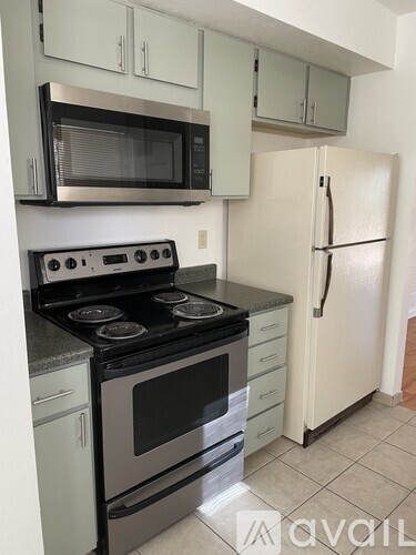 A kitchen with a black stove top oven and a white refrigerator.