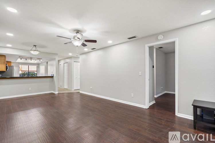 A spacious room with a ceiling fan and wooden flooring.