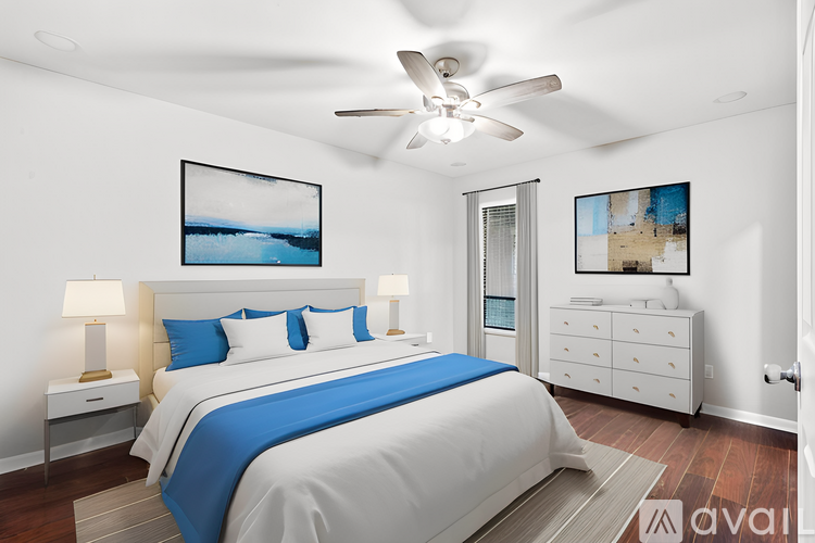 A bedroom with a large bed and a ceiling fan.