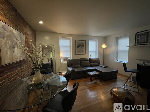 A living room with a glass table and a grey couch.