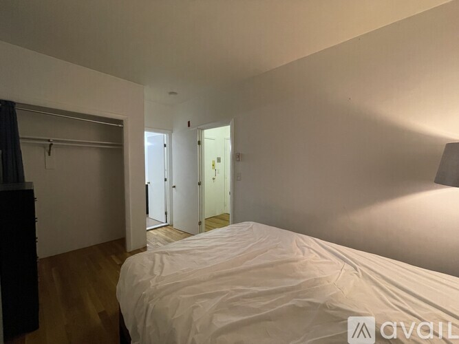 A bedroom with a bed, a wardrobe, and a mirror.