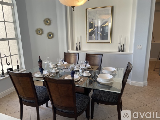 A dining room with a glass table and chairs.