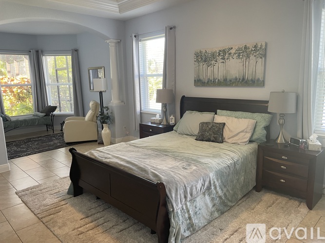 A bedroom with a large bed and a painting on the wall.