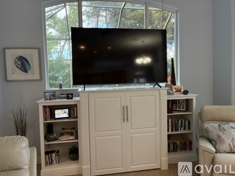 A living room with a television on top of a cabinet.