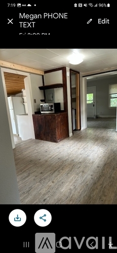 A room with wooden flooring and a wooden cabinet with a mirror above it.