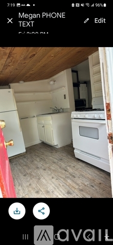 A kitchen with white appliances and wooden flooring.