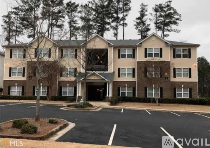 A large apartment complex with a parking lot in front.