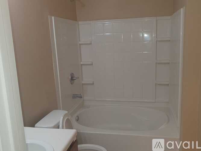 A white toilet sits next to a white bathtub in a bathroom.