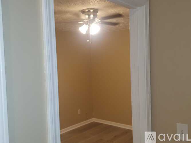 A room with a ceiling fan and light fixture.