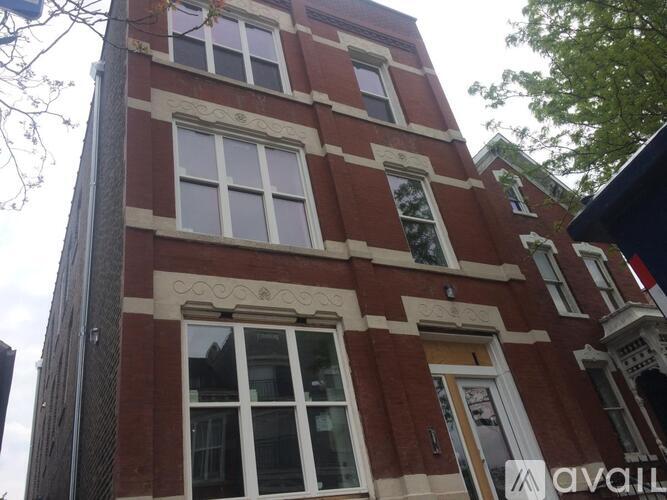 A tall red brick building with white trim and windows.