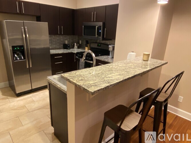 A kitchen with a granite countertop and stainless steel appliances.