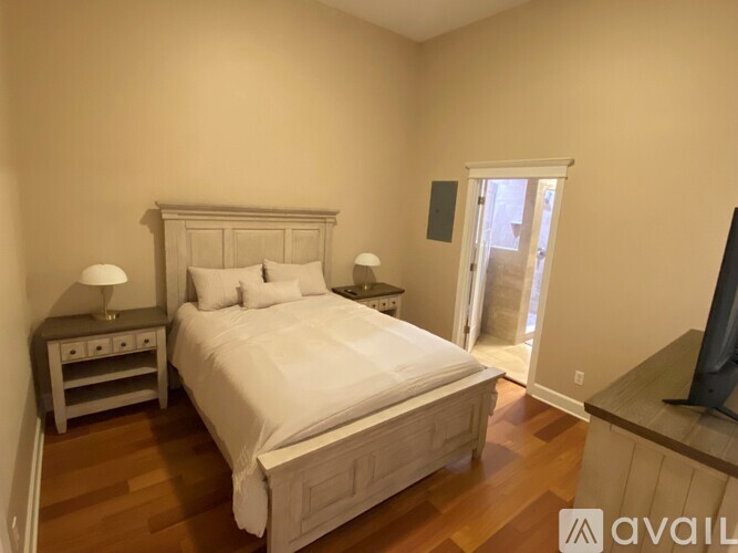 A bedroom with a large bed and a television on the side table.
