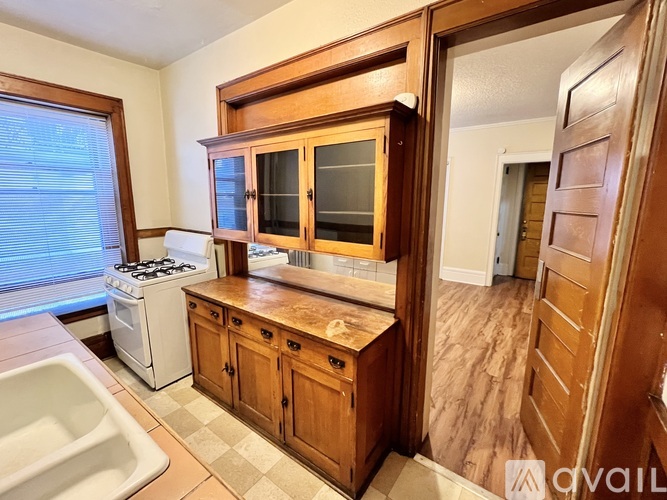 A kitchen with wooden cabinets and a white stove.