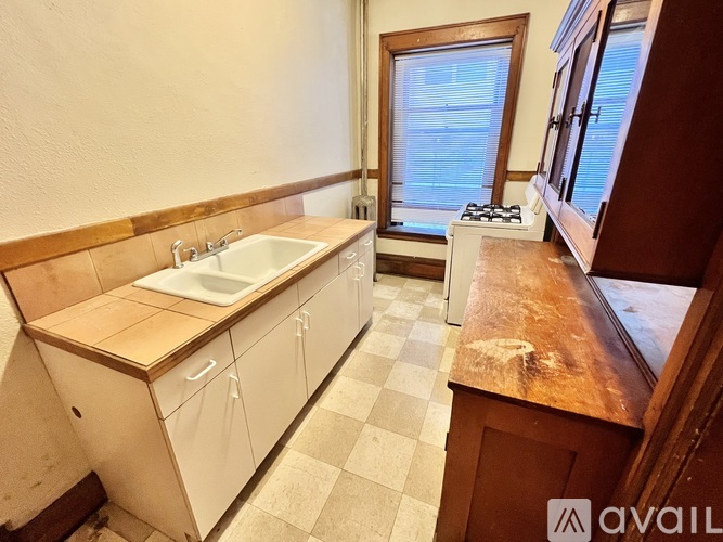 A kitchen with a sink, stove, and window.