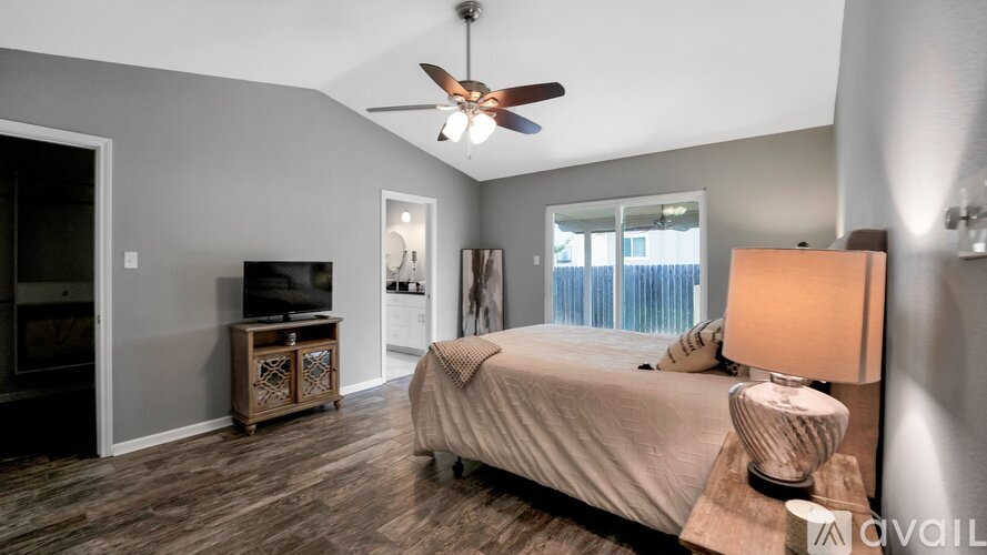 A bedroom with a bed, a ceiling fan, and a dresser.