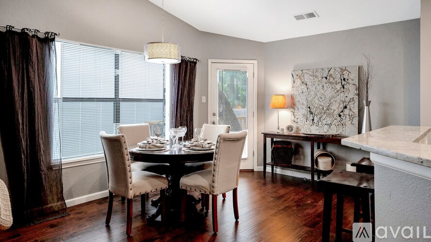 A dining room with a table set for four and a marble countertop.