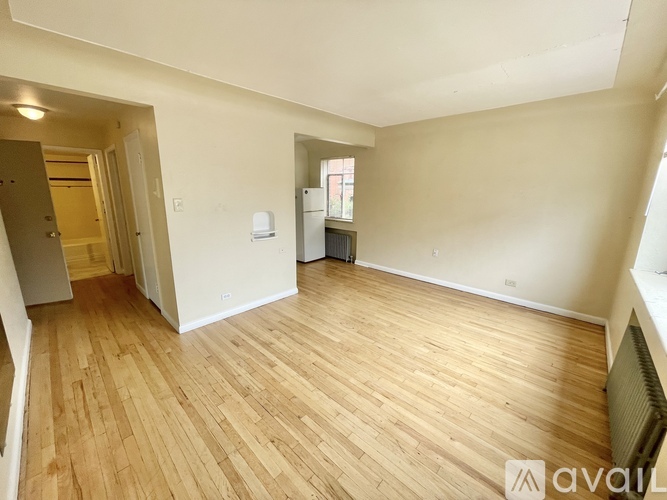A room with wooden flooring and a window.