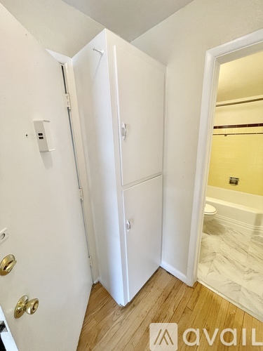 A white door with a gold handle is open.