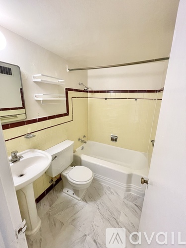 A bathroom with a toilet, sink, and bathtub.