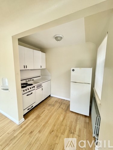 A kitchen with white appliances and wooden floors.