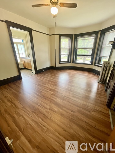 A room with wooden flooring and a ceiling fan.