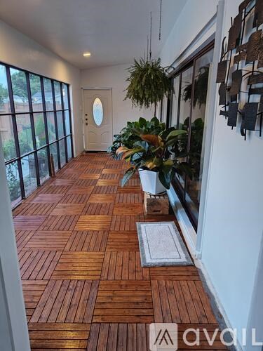 A hallway with wooden floors and a white door.
