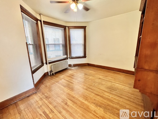 A room with wooden floors and a ceiling fan.
